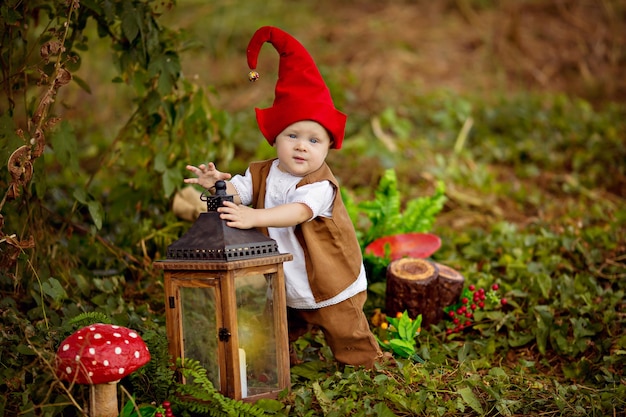 Happy fairytale baby gnome boy playing and walking in the forest eating apples