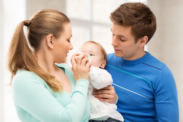 Famiglia felice e bambino adorabile con il biberon