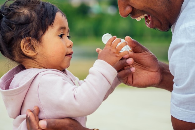 Happy family applying handsanitizer antibacterial gel to daughter hands