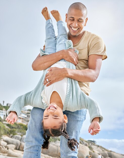 Счастливый семейный пляж и отец с дочерью веселятся вверх ногами во время отпуска во Флориде