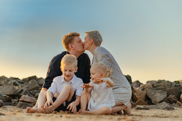 Foto famiglia felice sulla spiaggia mamma incinta figlio e figlia