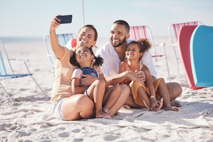 Photo happy family and beach selfie with smile together on summer vacation bonding and relaxing on the sand mother father and children relax on sandy shore holiday break or weekend smiling in happiness