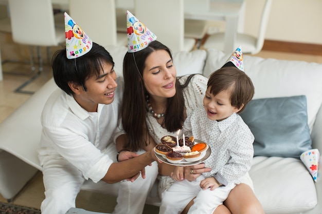 집에서 생일을 위해 함께 촛불을 불고 행복한 가족