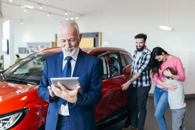 車のショールームで新しい車を買う幸せな家族