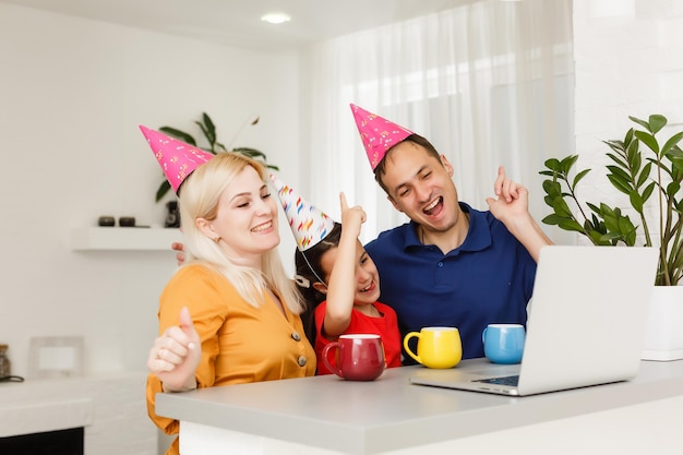 Happy family celebrating birthday via internet in quarantine time, self-isolation and family values, online birthday party