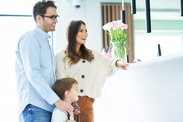 Famiglia felice che fa il check-in in hotel