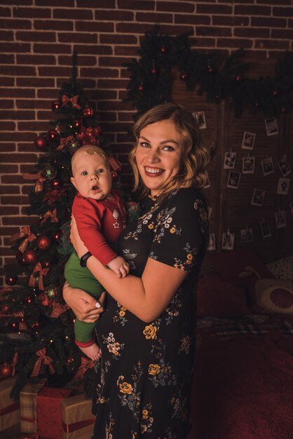 Photo happy family child celebrating new year and christmas at decorated christmas tree and garlands