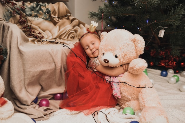 Bambini felici della famiglia che celebrano il nuovo anno e il natale all'albero di natale decorato e alle ghirlande