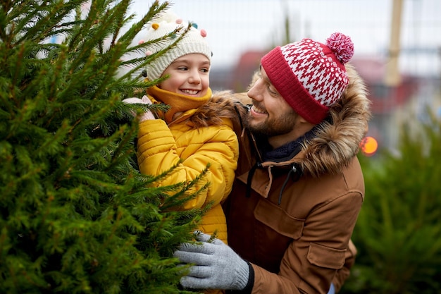 happy family choosing christmas tree at market