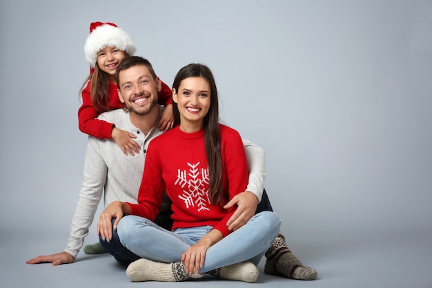 Happy family in Christmas mood on light background