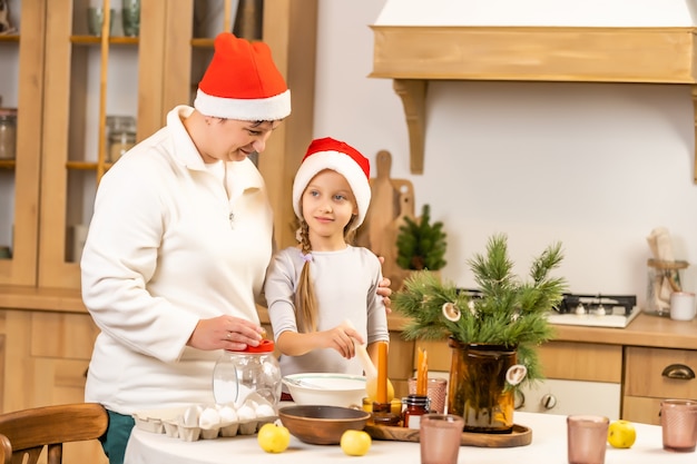 クリスマスに幸せな家族。家で楽しんでいる母と娘