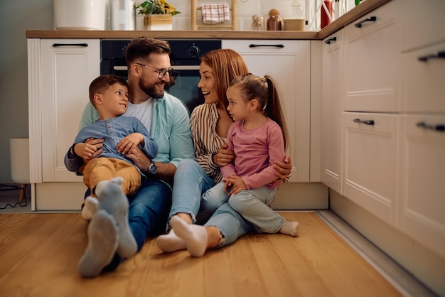 Happy family communicating while relaxing on the floor in the kitchen