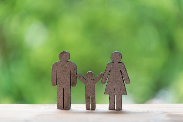 Happy family concept,father,mother and kid wood model with green nature background