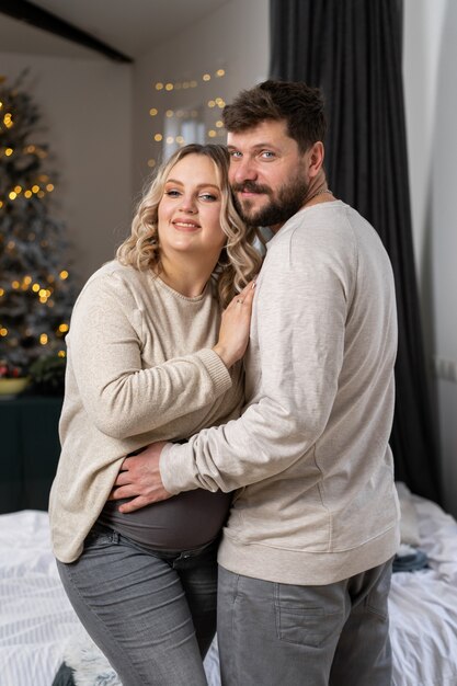 Happy family concept. husband hug belly pregnant wife standing indoor living room near sofa caucasian man and woman pregnancy and new life concept. love and care