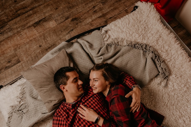 Happy family couple celebrating New Year and Christmas at decorated Christmas tree and garlands