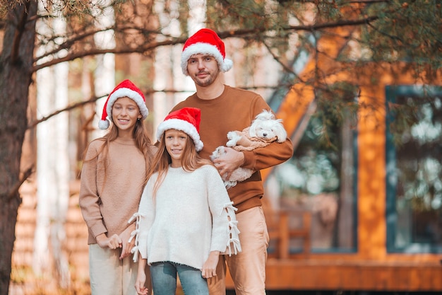 Famiglia felice di papà e bambini in cappello della santa godendo le vacanze di natale