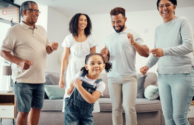 Happy family and dancing in playful living room fun together with entertainment in happiness at home Group of people in relationship bonding smiling and joyful funny dance at the house