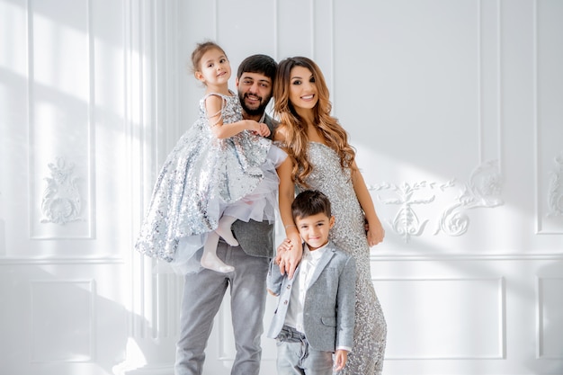 happy family in elegant clothes in the new year interior