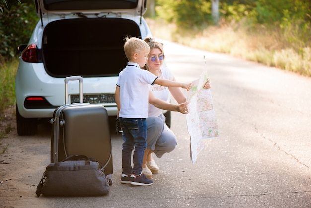 幸せな家族は車の旅行と夏休みを楽しんでいます。