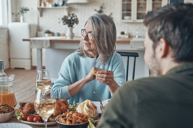 Happy family enjoying delicious dinner and smiling while sitting in the modern apartment