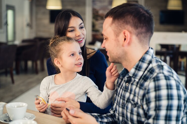 Happy family enjoying tea in cafe together