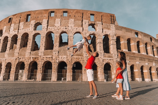 Happy family in Europe. Parents and kids in Rome over Coliseum