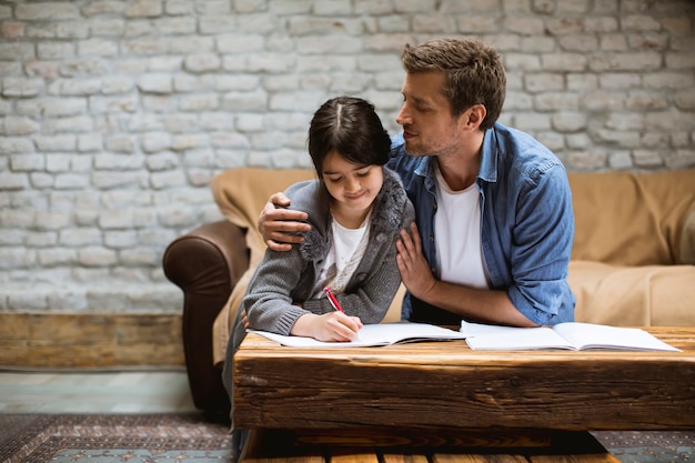 Happy family father and daughter doing homework at home