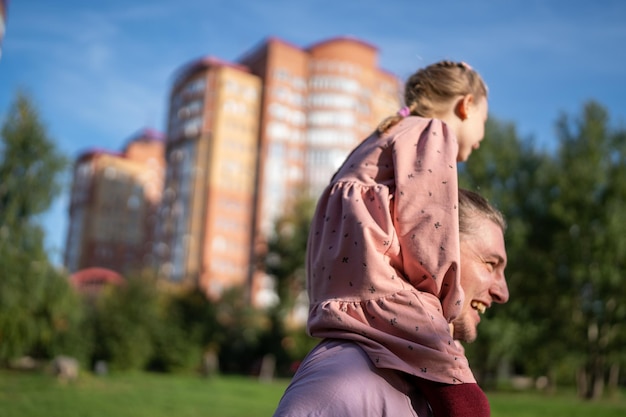 Photo happy family father day child girl leisure daughter sitting on father neck cute little kid having