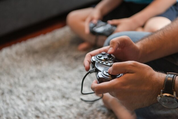 Photo happy family. father, mother and children playing a video game father and son playing video games together on the floor