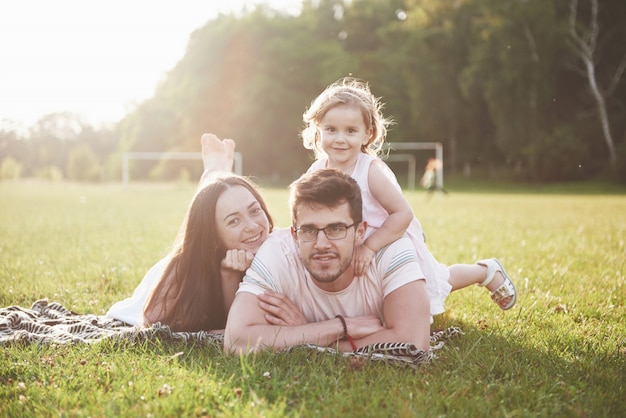 Happy family, father of mother and daughter of baby in the nature at sunset