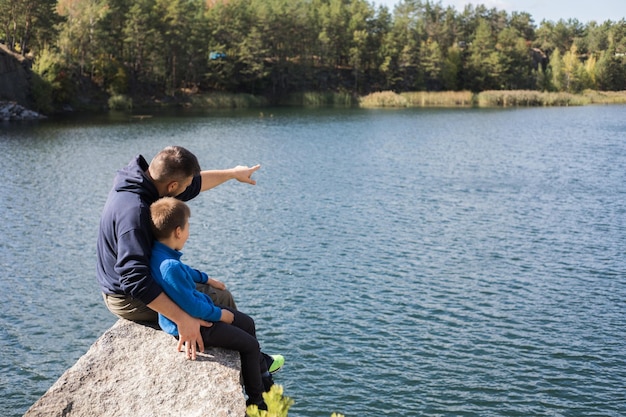 Happy family Father playing with son oudoors Positive human emotions feelings joy on the lake in Korostyshiv quarry Zhytomyr district northern Ukraine