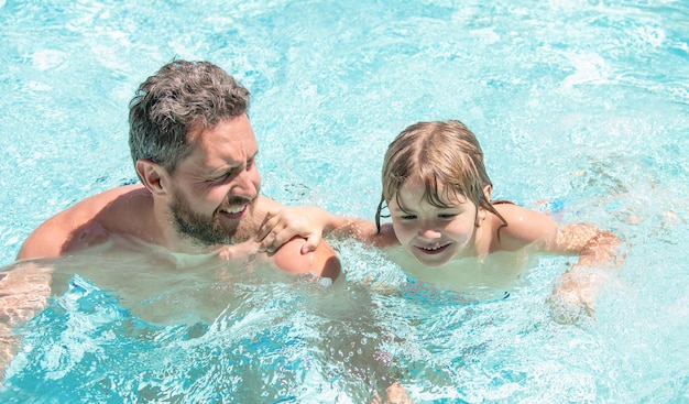 Happy family of father and small boy having fun in summer swimming pool, resort.