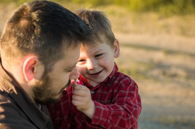 Foto famiglia felice. padre e figlio che giocano e abbracciano la vita all'aria aperta. festa del papà