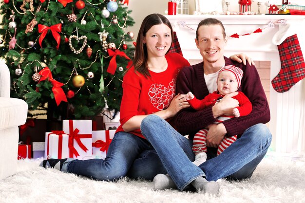 Happy family on the floor in the decorated Christmas room