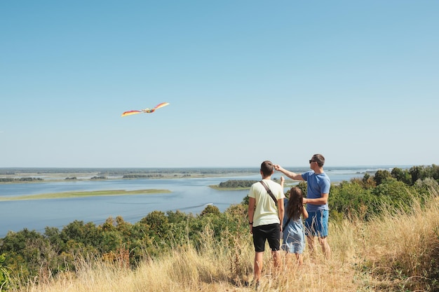 Happy family flying a kite outdoors Family on summer vacation