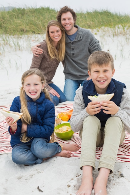 Счастливая семья из четырех человек на пляже пикник