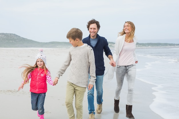 Happy family of four walking at beach