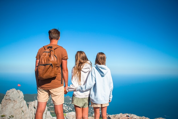 Happy family of four walking in the mountains