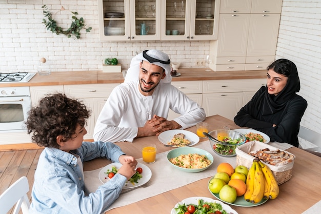 Famiglia felice degli emirati arabi uniti che mangiano insieme e celebrano le feste nazionali