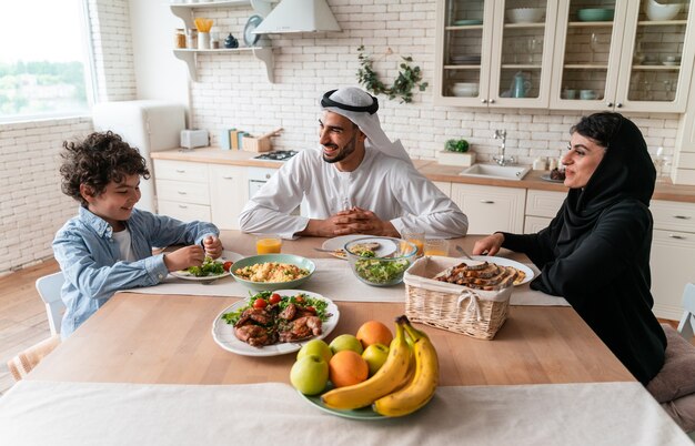 Happy family from arab united emirates eating together and celebrating the national day holidays