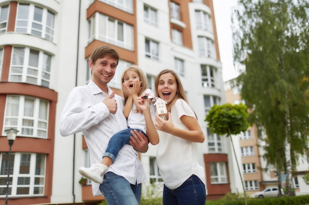 Happy family in front of new apartment building