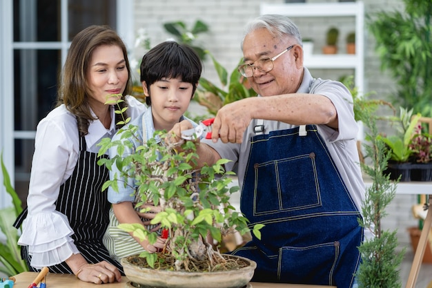 Happy family gardening together in the garden, grandfather grandson and woman taking care of nature