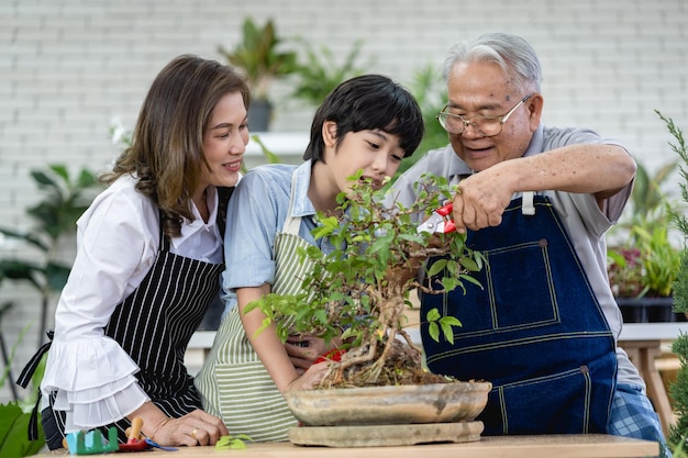 Photo happy family gardening together in the garden grandfather grandson and woman taking care of nature