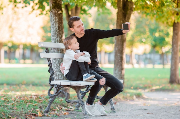 La famiglia felice si diverte a prendere selfie sulla bella giornata autunnale