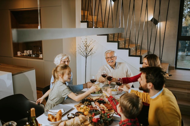 写真 家で赤ワインと夕食を食べている幸せな家族