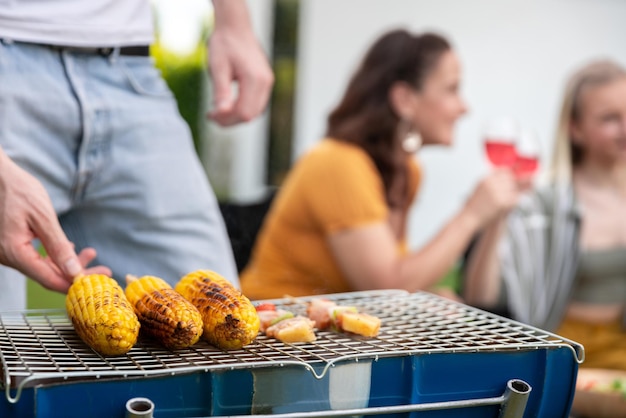 Happy family having barbecue bbq party with red wine in outdoor backyard garden of house with happy