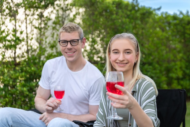 Happy family having barbecue bbq party with red wine in outdoor backyard garden of house with happy