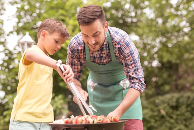 Happy family having barbecue on sunny day