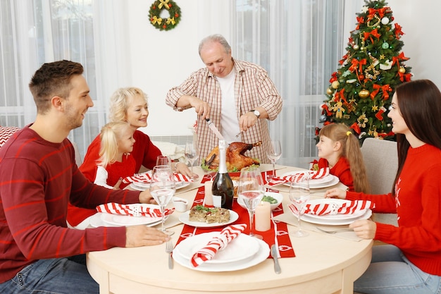 リビングルームでクリスマスディナーを持っている幸せな家族