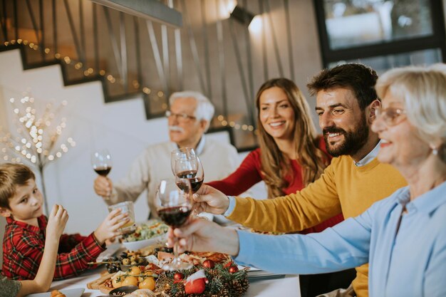 家で赤ワインと夕食を食べている幸せな家族